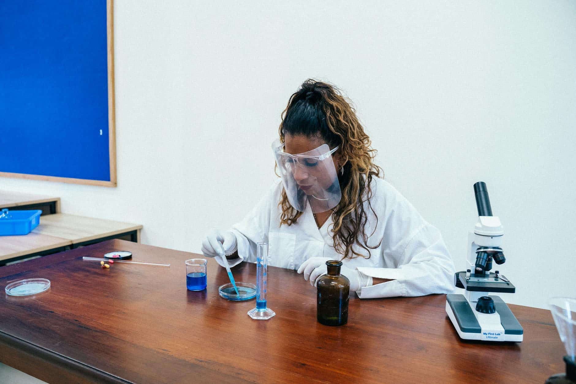 female scientist working in lab with blue chemical sample