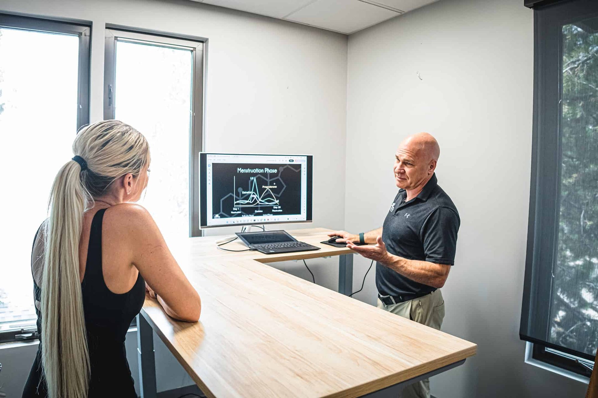 man explaining menstrual cycle chart to blonde woman