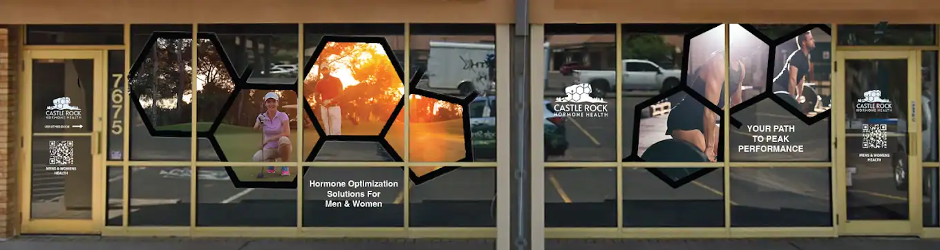 Storefront windows feature hexagonal images of people exercising, running, and relaxing outdoors, along with logos and text reading “Castlerock Medical Plaza” and “Hormone Optimization Solutions For Men & Women.”.